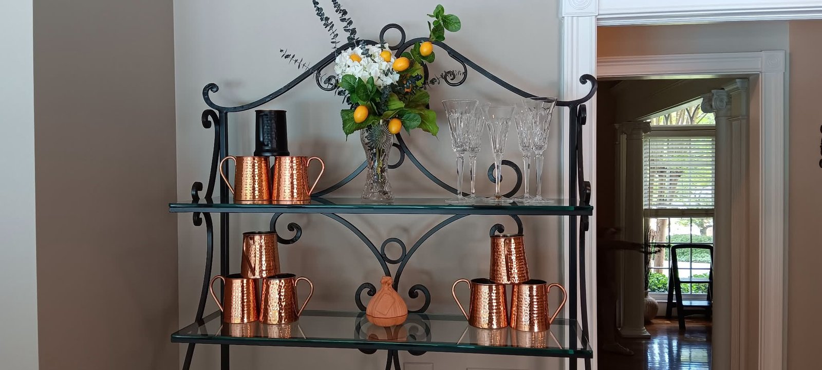 Styled baker's rack with copper mugs and flowers